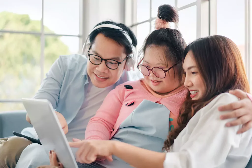 Disabled girl with parents looking at iPad